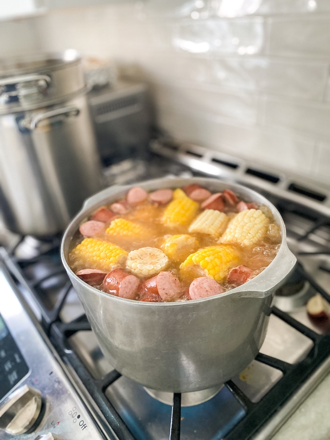 pot of boiling corn, potatoes, shrimp and sausage