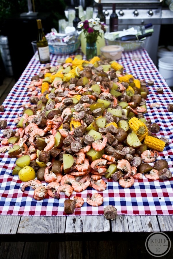 low country boil food spread over picnic table