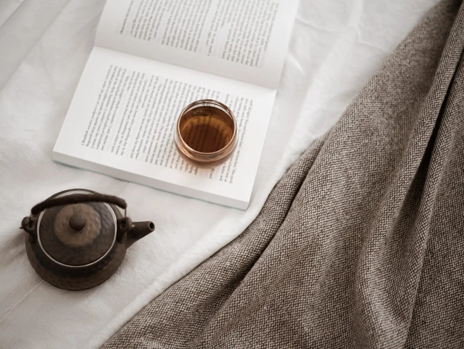 pot of tea next to a book pot of tea next to a book