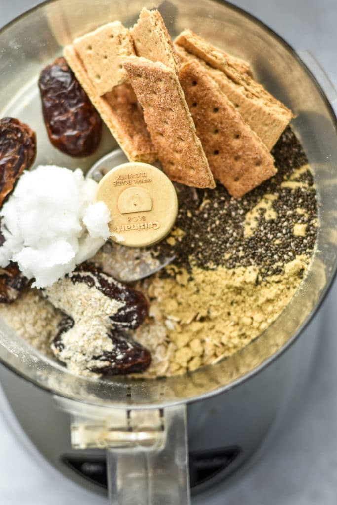 ingredients in a food processor like graham crackers, coconut oil and chia seeds