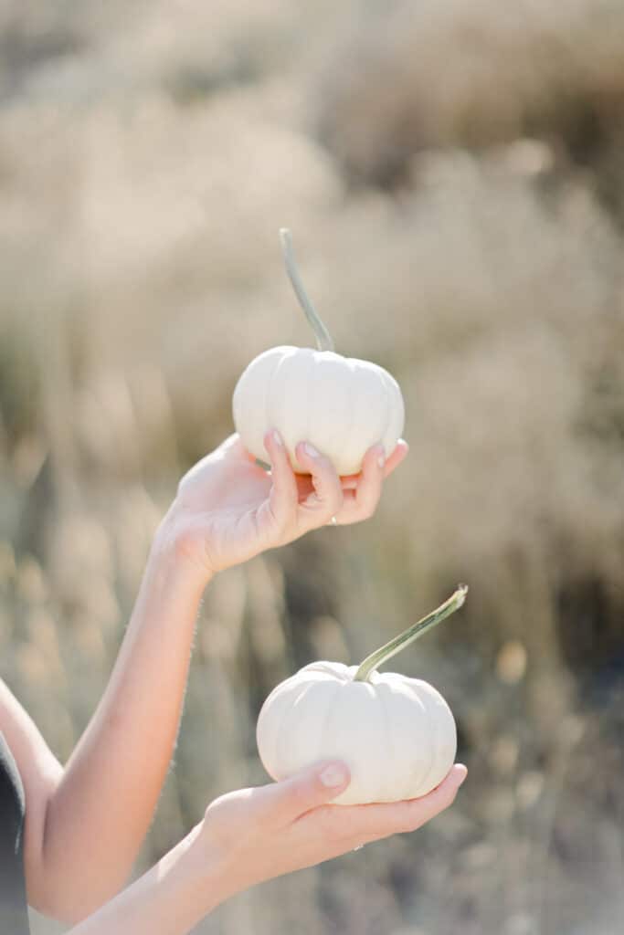 white small pumpkins Kath Eats Blogger Kath Younger shares Healthy Habits For Fall: in photo: person holding two white small pumpkins