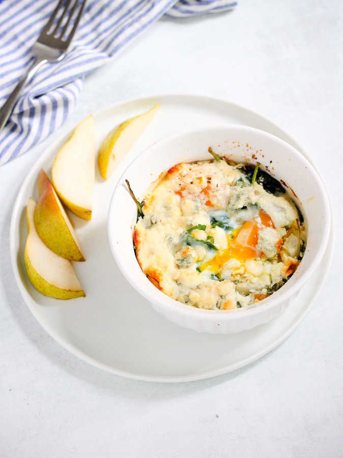 baked eggs with blue cheese and pear on a plate