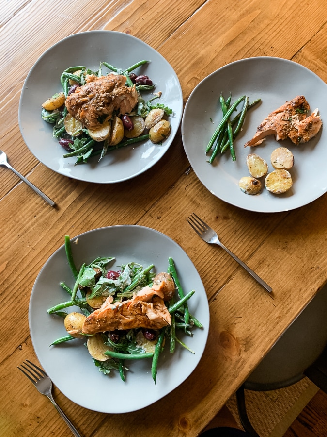 dinner plates with salmon, green beans, and potatoes