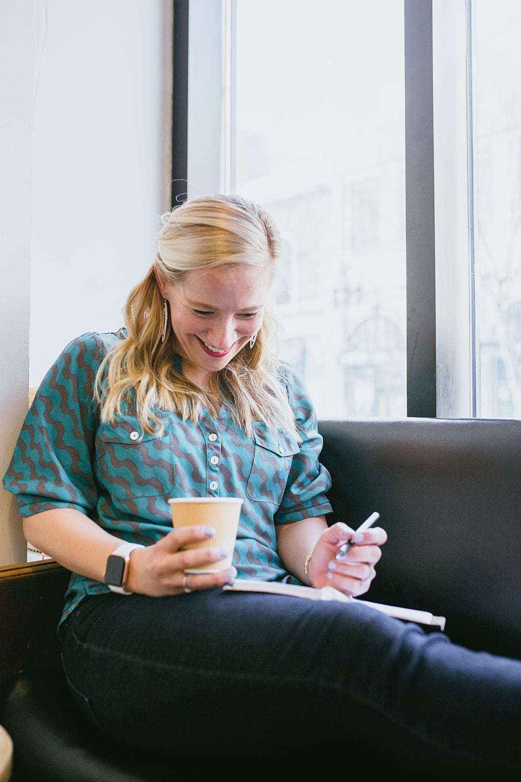 kath younger taking notes with coffee and smiling