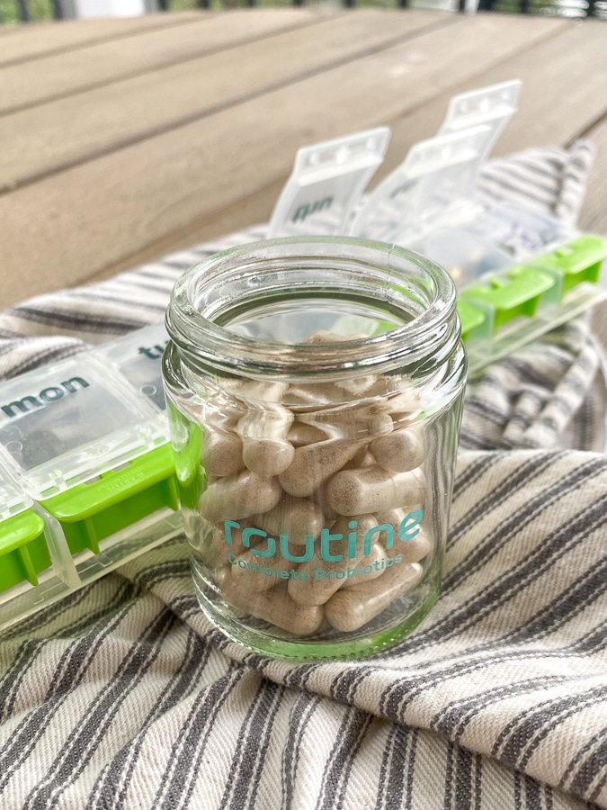 Routine probiotics in a glass jar on a farmhouse napkin