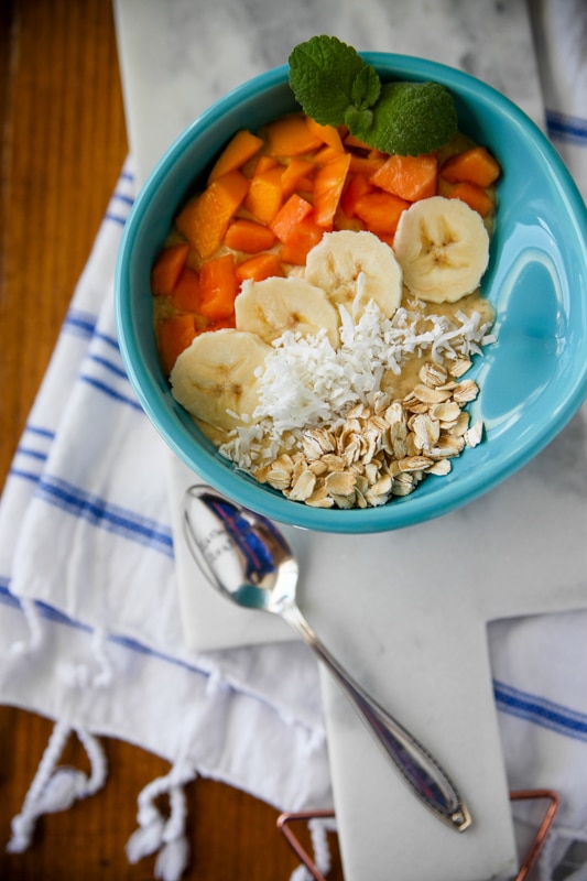 Overhead shot of a tropical smoothie bowl in a turquoise bowl