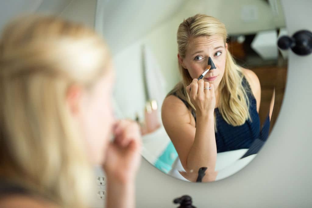 kath putting on charcoal mask at sink