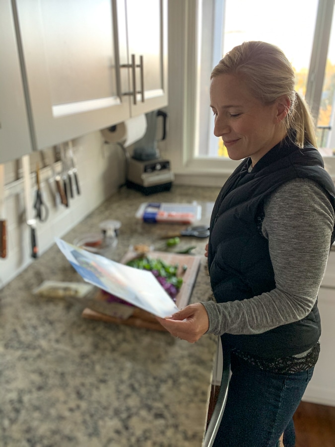 Kath reading a blue apron recipe card in her kitchen