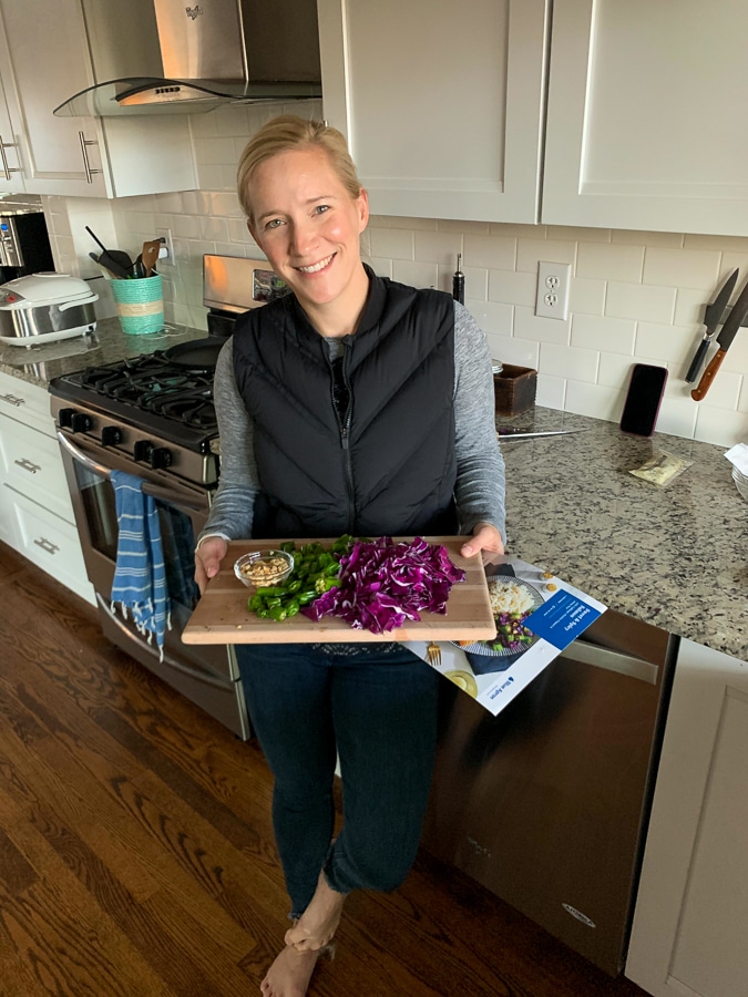 kath holding a cutting board with chopped cabbage