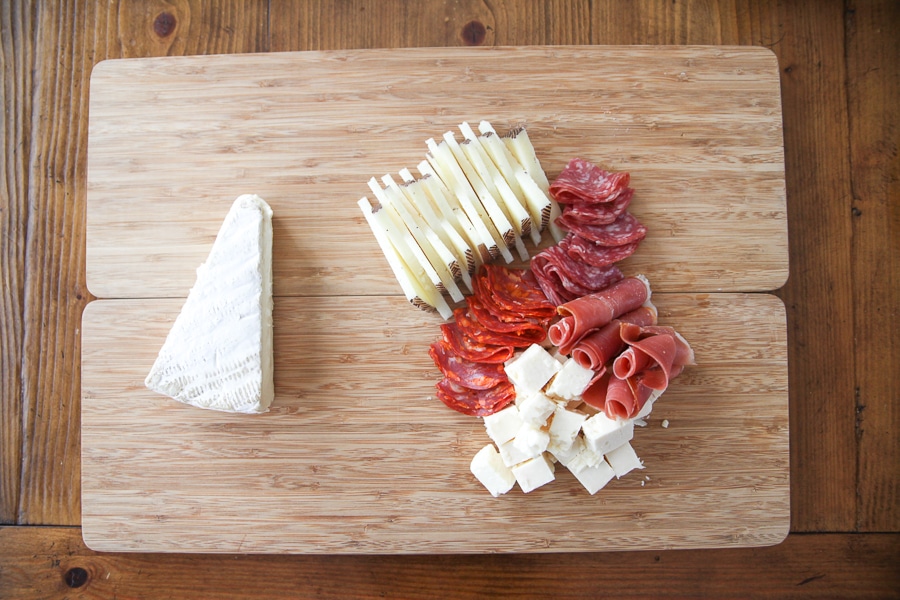 cheeses and meats on a cutting board