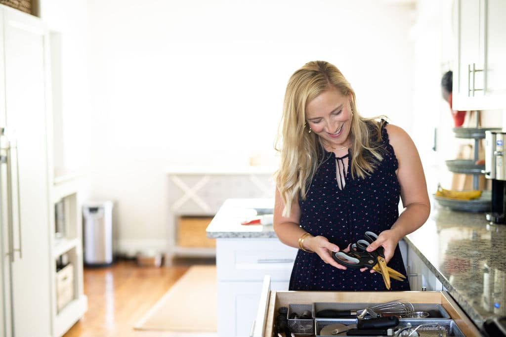 Kath in kitchen opening drawer of kitchen tools.