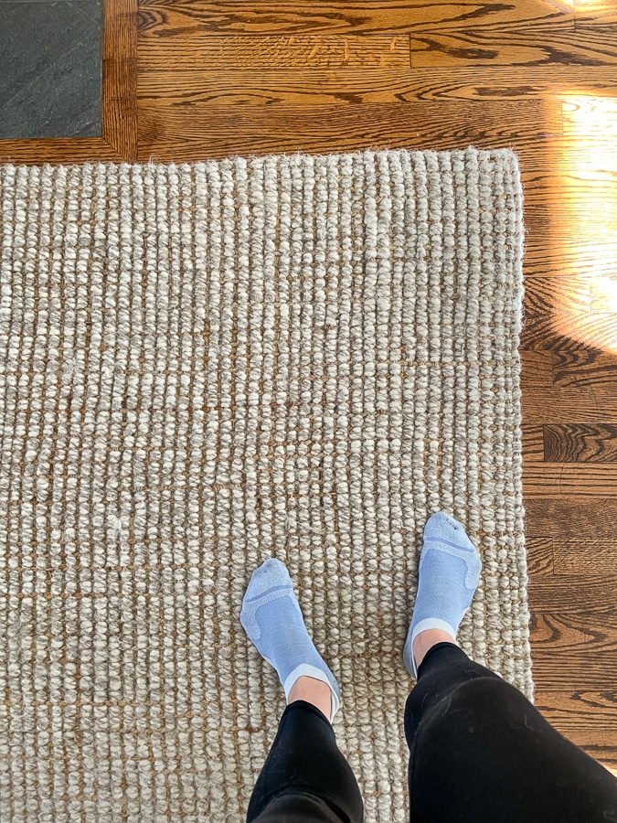 Pottery Barn jute and wool rug with feet in socks