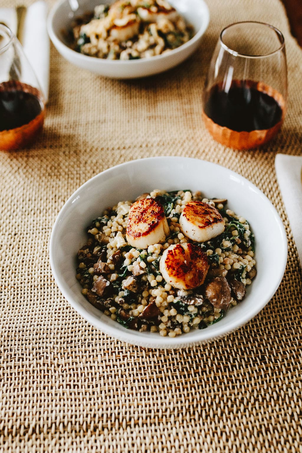 perfectly seared scallops on top of couscous and mushroom dish