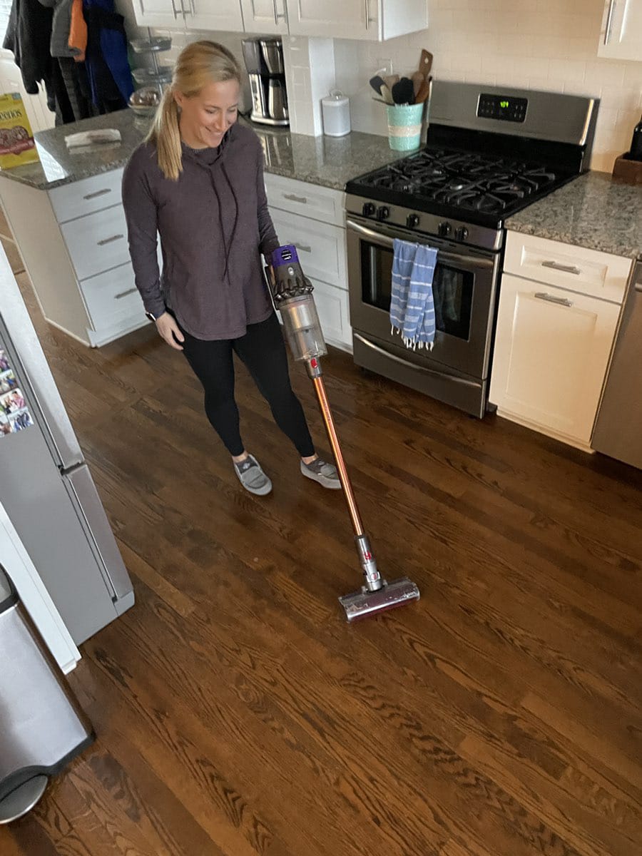 Dyson Cordless Absolute vacuum woman using Dyson cordless vacuum
