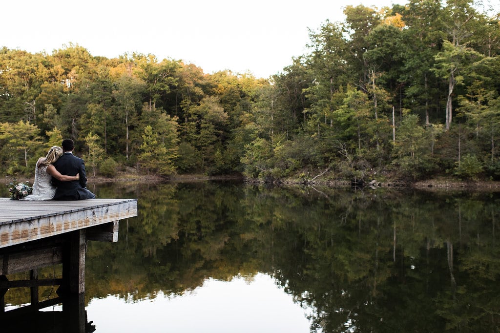 husband and wife sit on a dock together