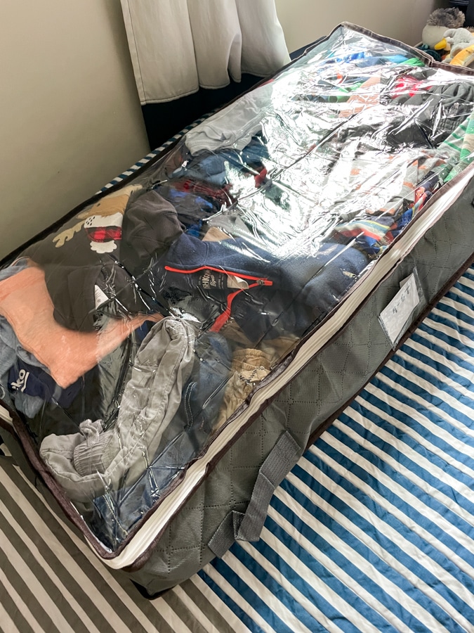 Underbed storage bin full of clothes