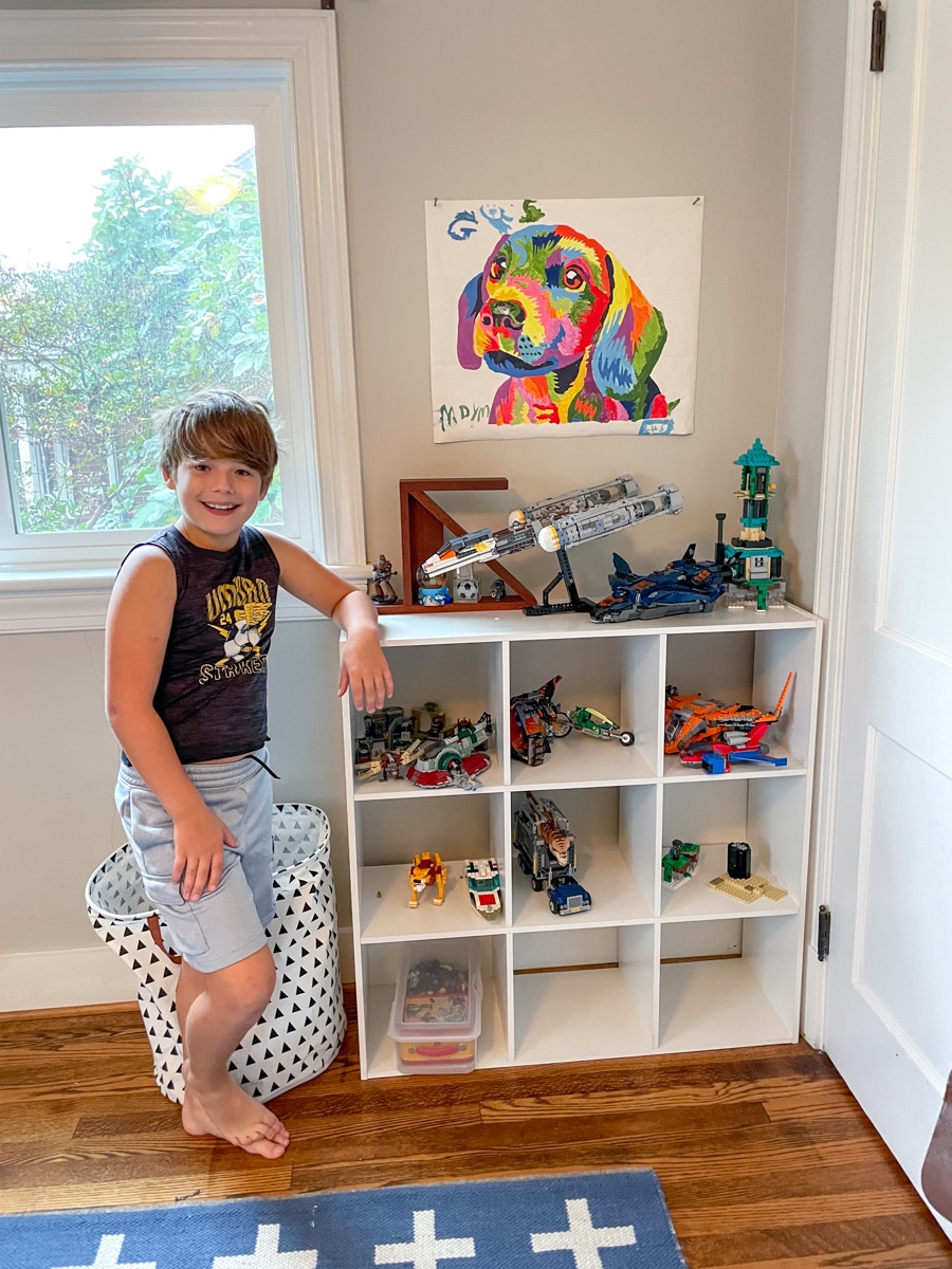kid organizing lego shelf